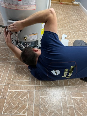 ferrer plumbing employee fixing water heater